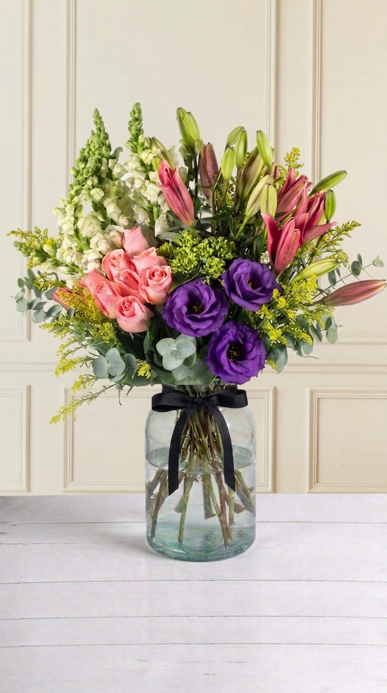 Arreglo 9 Rosas Claritas, 6 Lilys Rosas, 3 Lisianthus, Perrito Blanco con Solidago y Eucalipto - En Florero | MJO